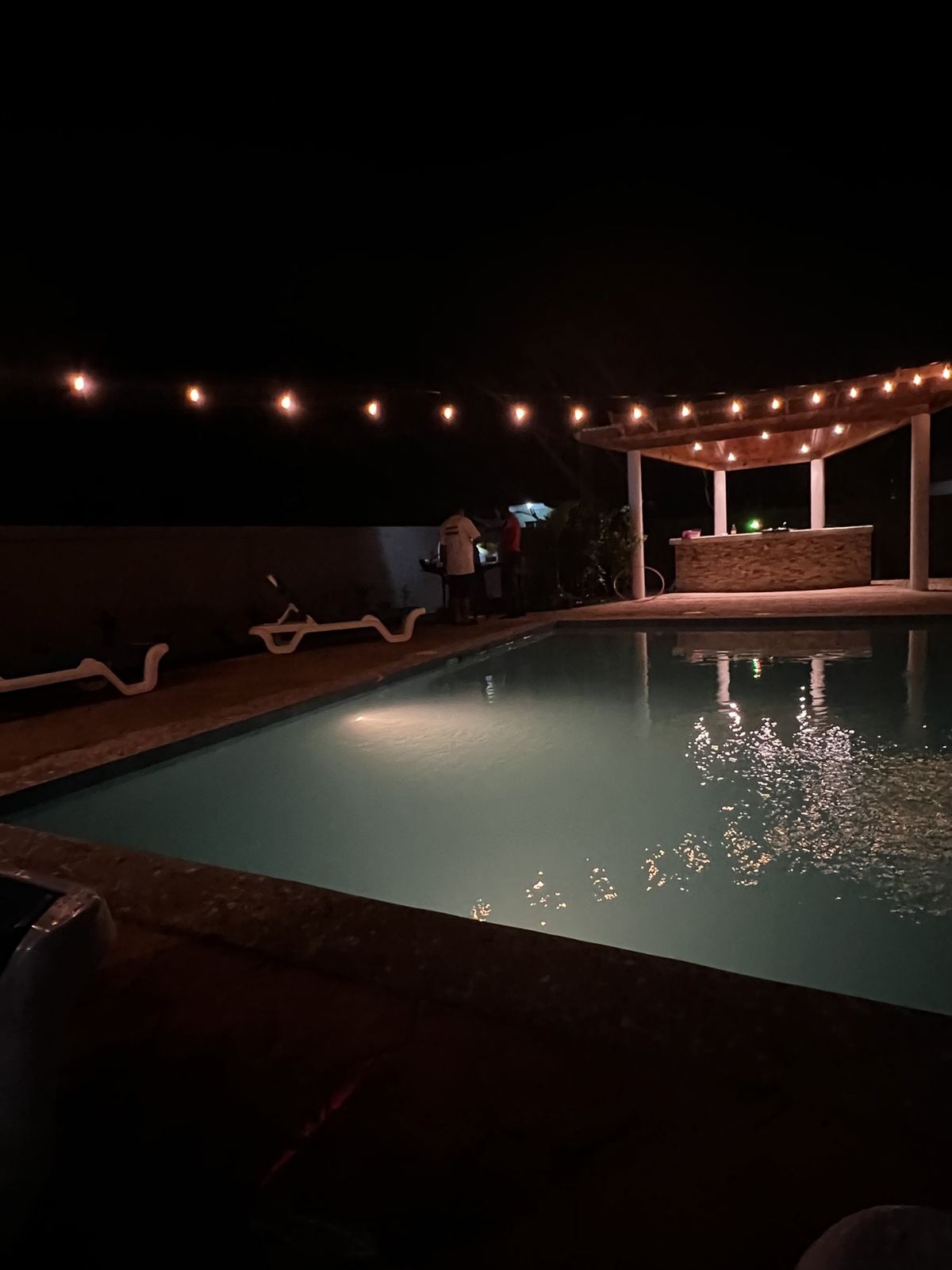 Paradise Palms pool at night beside the string-lit pergola bar